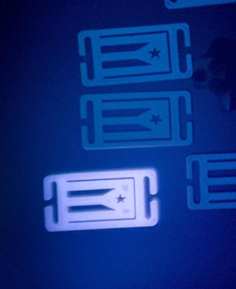 May include: Four white plastic keychains with a design of the Puerto Rican flag. The flag is white with three red horizontal stripes and a blue star in the upper right corner.