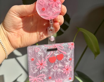 Floral, cherries and bow design marker Parker with matching badge reel and a pink shimmer background.