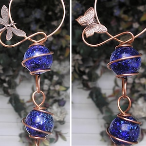 May include: Copper wire wind chime with two blue glass orbs and a dragonfly at the top.