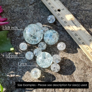 May include: A ruler measuring 1 3/8 inches, 1/2 inch, and 1 inch, with a collection of clear glass marbles of various sizes. The marbles are scattered on a gray, textured surface. Size Examples - Please see description for size(s) used.