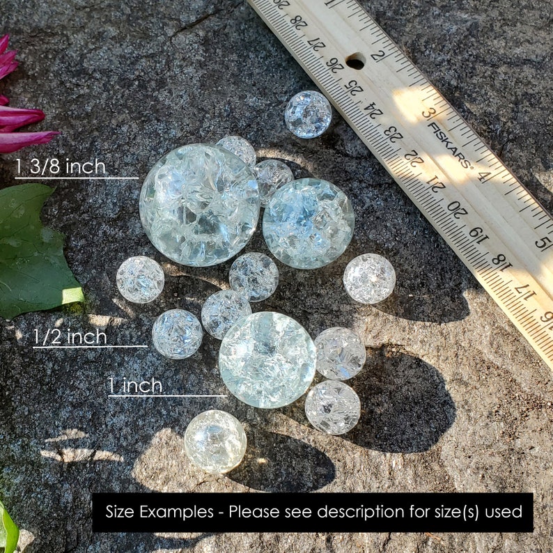 May include: A ruler measuring 1 3/8 inches, 1/2 inch, and 1 inch, with a collection of clear glass marbles of various sizes. The marbles are scattered on a gray, textured surface. Size Examples - Please see description for size(s) used.