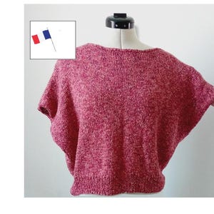 Peut inclure: Un haut en tricot rouge et blanc moucheté à manches courtes et col bateau.