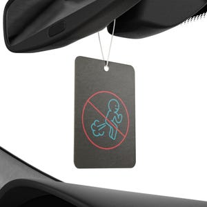 Könnte beinhalten: Ein schwarzer Auto-Lufterfrischer mit einem roten Kreis und einem Strich durch ihn. Im Kreis befindet sich eine weiße Strichmännchenfigur mit einer blauen Furzkwolke, die aus seinem Hinterteil kommt.