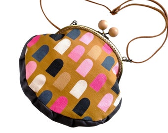 Pink and caramel arches mod design metal frame bag with wooden bobbles and leather strap