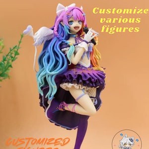May include: A colorful, custom-made figurine of a female anime character with long, rainbow-colored hair, wearing a purple and white dress, holding a microphone. The figurine is standing on a black base with the text "CUSTOMIZED FIGURES" and a logo with the text "Zovustore".