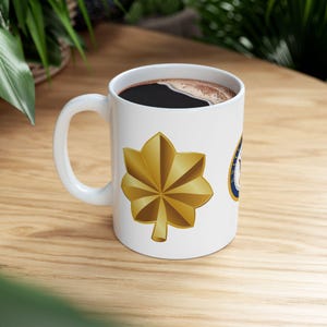 May include: A set of three ceramic mugs with a speckled, matte finish. The mugs are in shades of cream, light grey, and dark grey. Each mug has a simple, minimalist design, ideal for coffee or tea.