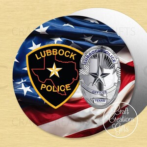 May include: A round decorative item featuring a stylized American flag design. It includes a Lubbock Police badge and a Texas star badge. The item has the words "Lubbock Police" and "Officer Texas" on it.