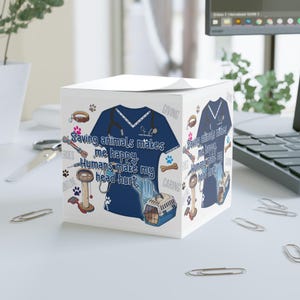 May include: A white cube notepad featuring a blue medical scrubs design with the text "Saving animals makes me happy. Humans make my head hurt." The design includes paw prints, a stethoscope, and a pet carrier.