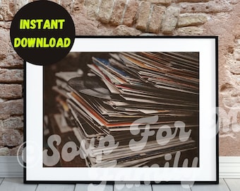 Può includere: Una pila di dischi in vinile vintage in una cornice nera. I dischi sono disposti in ordine casuale e sono principalmente di colore marrone e nero.