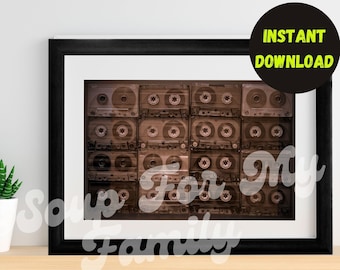 May include: A framed print of a wall of vintage cassette tapes in a black frame with a white mat. The tapes are all brown and have a faded look. The print is perfect for a music lover's home.