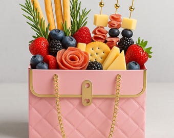 May include: A pink, quilted handbag-shaped container filled with an assortment of food items. The arrangement includes strawberries, blueberries, blackberries, cheese, crackers, and skewers with cheese and meat. Gold chain handles and trim.