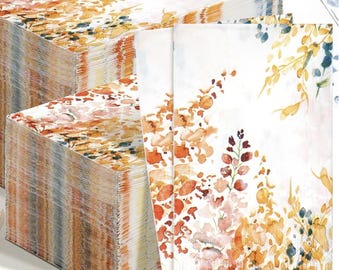 May include: Stacks of white paper napkins with a watercolor floral design in shades of orange, yellow, and blue. The napkins have a rectangular shape and are stacked neatly, showcasing the detailed artwork.