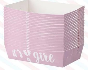May include: A stack of light pink paper trays with white interiors. The trays have a rectangular shape with a slightly curved top edge. The phrase "it's a girl" is printed in white on the front of the trays, along with two baby footprints.