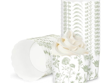 May include: White cupcake cases with a scalloped edge and a delicate green floral pattern. One case holds a cupcake with white frosting. A stack of cases is visible, suggesting a baking theme.