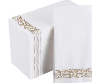 May include: A stack of white paper napkins with a gold decorative border. The napkins are rectangular and have a textured surface. The gold border features an ornate, swirling design.