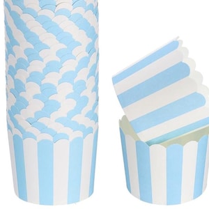 May include: A stack of blue and white striped cupcake liners with scalloped edges. Two additional liners are displayed, one nested inside the other. The liners are light blue and white, perfect for baking cupcakes or muffins.