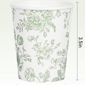 Op de afbeelding: Witte papieren beker met een groen bloemmotief. De beker heeft een diameter van 7,6 cm, is 8,9 cm hoog en heeft een diameter van 5,3 cm aan de basis. Het bloemmotief omvat rozen en andere bloemen.