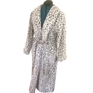 May include: A plush, long-sleeved bathrobe featuring a white and gray leopard print pattern. The robe includes a wide shawl collar, long sleeves with cuffs, and a matching fabric tie belt at the waist to secure the garment closed in the front.