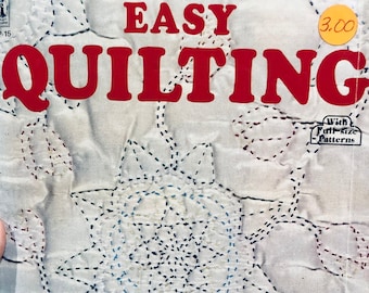 May include: A book titled "EASY QUILTING" with a price tag of $3.00. The cover features a white fabric background with a blue and red floral design. The text "With Full-Size Patterns" is printed on the cover.