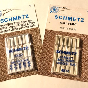 May include: Two packages of Schmetz sewing machine needles. The package on the left contains Jersey/Ball Point needles in sizes 70, 80, 90, and 12. The package on the right contains Ball Point needles in size 80/12.