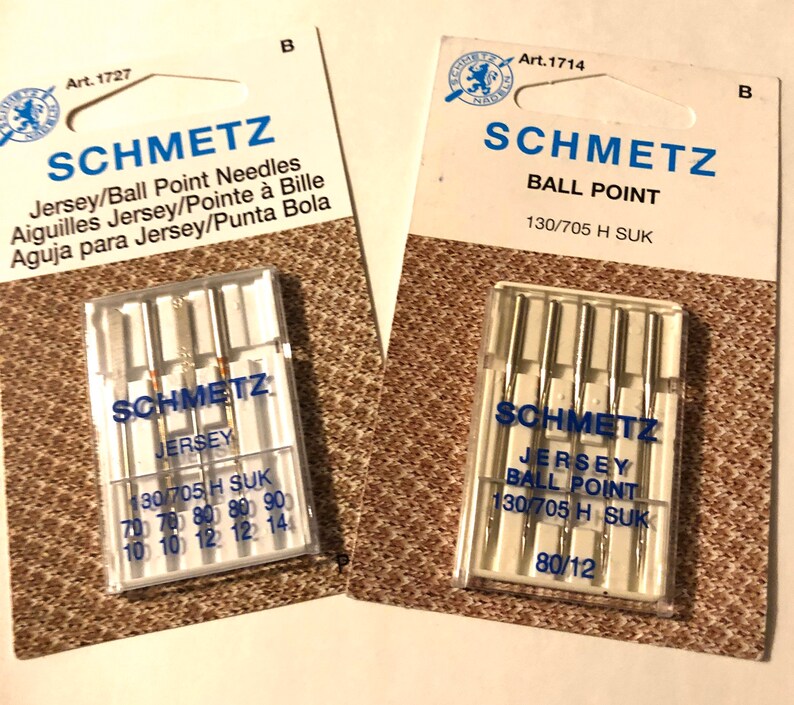 May include: Two packages of Schmetz sewing machine needles. The package on the left contains Jersey/Ball Point needles in sizes 70, 80, 90, and 12. The package on the right contains Ball Point needles in size 80/12.