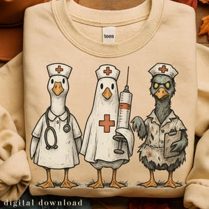 Puede incluir: Sudadera beige con una ilustración caprichosa de tres gansos vestidos como profesionales médicos. Un ganso lleva una bata de médico y un estetoscopio, otro sostiene una jeringa y el tercero tiene una carpeta. La palabra "tees" está en la etiqueta.