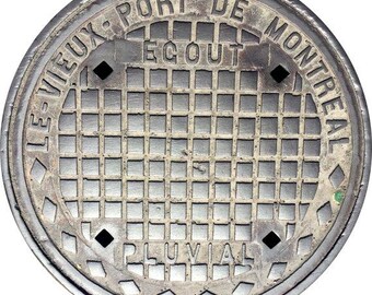 May include: A circular, weathered metal manhole cover. The cover features the text "LE VIEUX PORT DE MONTREAL" and "ÉGOUT PLUVIAL" in a circular pattern. The center has a grid pattern.