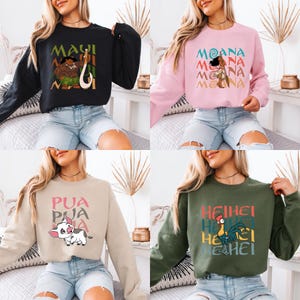 Puede incluir: Cuatro im&aacute;genes recortadas diferentes de mujeres que llevan sudaderas de manga larga con varios personajes de Disney Moana impresos en ellas. Las sudaderas son de color negro, rosa, beige y verde.