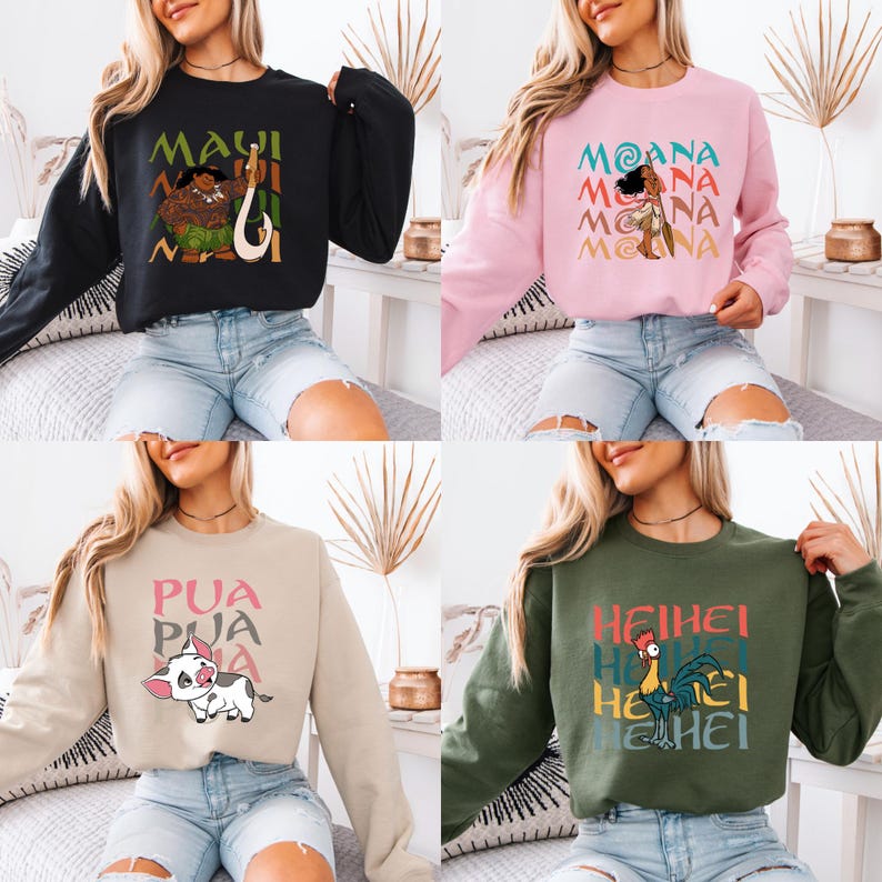 Puede incluir: Cuatro im&aacute;genes recortadas diferentes de mujeres que llevan sudaderas de manga larga con varios personajes de Disney Moana impresos en ellas. Las sudaderas son de color negro, rosa, beige y verde.