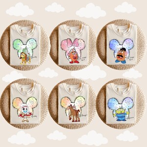 Puede incluir: Seis camisetas blancas con un dise&ntilde;o de cabeza de Mickey Mouse con diferentes personajes de Toy Story. Los personajes incluyen Slinky Dog, Mr. Potato Head, Buzz Lightyear, Woody, Bo Peep y Jessie. Cada camiseta tiene un dise&ntilde;o de fuegos artificiales de colores.