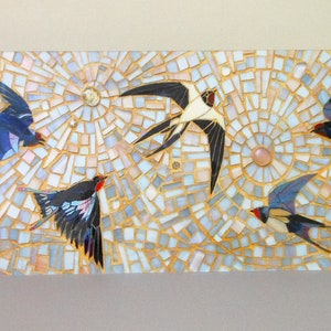 May include: Mosaic artwork featuring five stylized birds in flight against a background of white, gold, and light blue tiles. The birds are depicted in shades of blue, black, and red.
