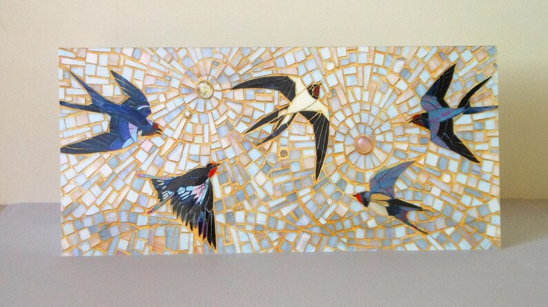 May include: Mosaic artwork featuring five stylized birds in flight against a background of white, gold, and light blue tiles. The birds are depicted in shades of blue, black, and red.