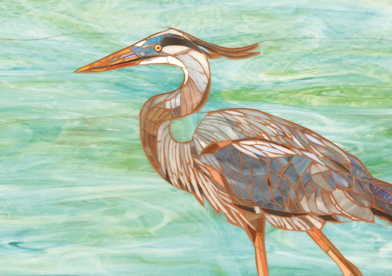 May include: A mosaic art piece depicting a blue heron with a long neck and beak, standing on a turquoise and green background.
