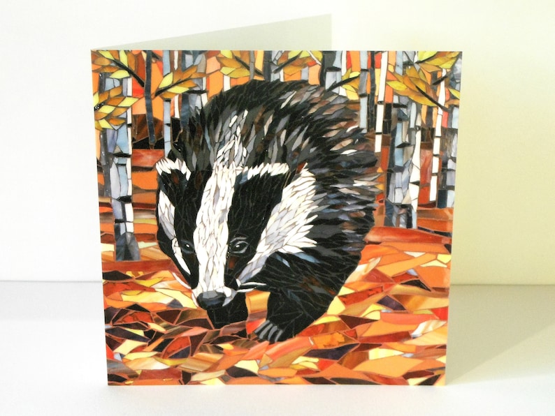 May include: A mosaic art card featuring a badger walking through a forest of birch trees with autumn leaves on the ground.