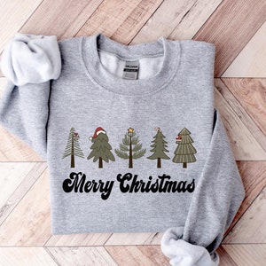 May include: Gray sweatshirt with a graphic of five stylized Christmas trees and the text "Merry Christmas" in a retro font.
