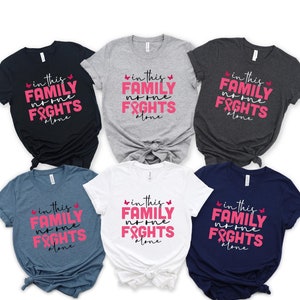 In questa famiglia nessuno combatte da solo, maglietta per chi combatte contro il cancro al seno, maglietta per la famiglia per la sensibilizzazione sul cancro, maglietta coordinata per la famiglia contro il cancro, al diavolo il cancro