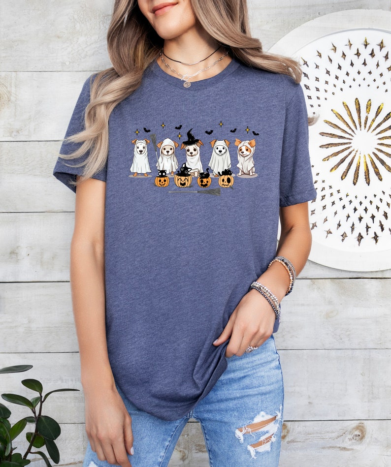 Op de afbeelding: Een marineblauw T-shirt met een afbeelding van vijf honden die verkleed zijn als geesten voor Halloween. De honden dragen witte geestkostuums en hebben pompoenen voor zich.