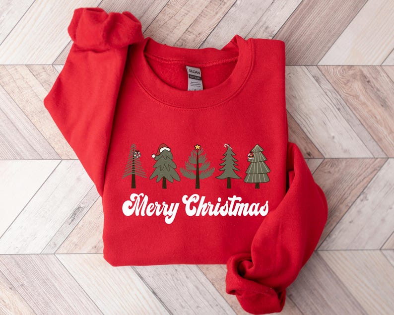 May include: Red Christmas sweatshirt with a white graphic of five stylized Christmas trees and the text "Merry Christmas".