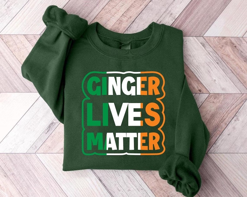 May include: Green sweatshirt with a white and orange graphic that says "Ginger Lives Matter" in a bold font.