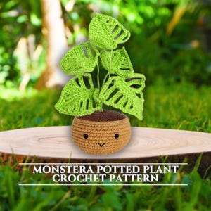 May include: A crocheted monstera plant in a brown pot with a cute face. The plant is sitting on a wooden surface with green grass in the background. Monstera Potted Plant Crochet Pattern.