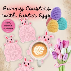 May include: Four pink crocheted bunny coasters with a cup of coffee on one of them. There are also three crocheted Easter eggs in purple, yellow, and blue.