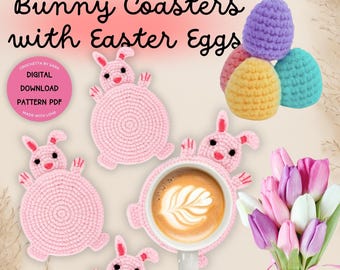 May include: Four pink crocheted bunny coasters with a cup of coffee on one of them. There are also three crocheted Easter eggs in purple, yellow, and blue.