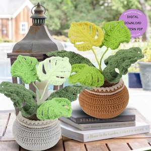 Puede incluir: Dos plantas en maceta de ganchillo con hojas verdes, amarillas y blancas. Las macetas son marrones y grises con ribete blanco. El texto en la etiqueta morada dice "Crochet by Sara, Descarga digital del patrón PDF, Con amor."