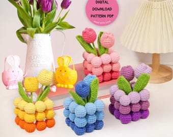 May include: A collection of handmade crochet tulip flower arrangements in various colors, including orange, yellow, pink, blue, and purple. The image also features a white pitcher with purple tulips and decorative bunny figurines.