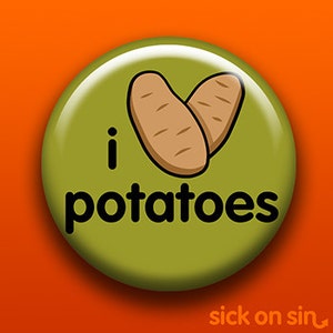 Könnte beinhalten: Ein grüner Knopf mit dem Text "i love potatoes" in schwarzen Buchstaben. Zwei braune Kartoffeln sind in Form eines Herzens gezeichnet.
