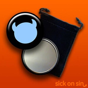 K&ouml;nnte beinhalten: Ein schwarzer Kompaktspiegel mit einem hellblauen Teufelsgesicht-Design und einem schwarzen Samtbeutel mit Kordelzug. Der Spiegel ist rund und hat einen silbernen Rand. Der Text "sick on sin" ist unten rechts zu sehen.