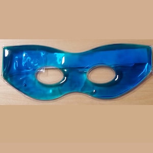 May include: Blue gel eye mask with two eye holes. The mask is made of a clear plastic material and is filled with a blue gel.