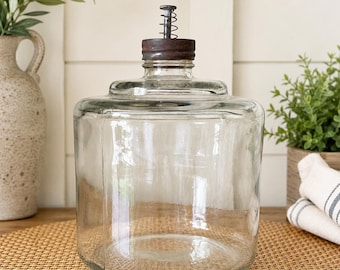 Vintage clear glass kerosene bottle with a rustic metal spring-loaded cap, Circa 1930-1950