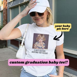 May include: White t-shirt with a photo of a baby and the text "Last Crawl Before We Walk". The text "your baby pic here" is written on a yellow rectangle with an arrow pointing to the photo. The text "custom graduation baby tee!!" is written on a pink rectangle at the bottom of the image.