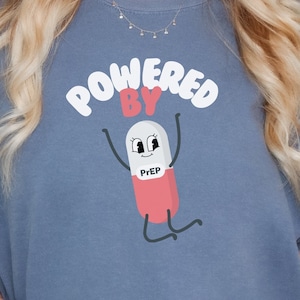 May include: A blue t-shirt with the text "Powered by" and a cartoon pill with the text "Prep" on it.